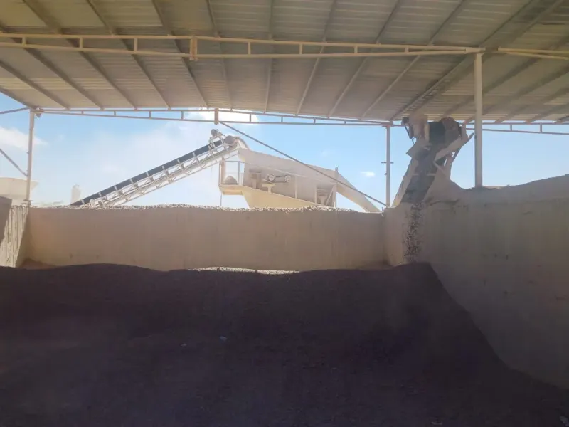 Aggregate stockpile and belt conveyor on site